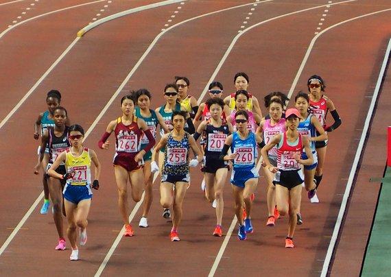 「第104回日本陸上競技選手権大会・長距離種目」の女子5000メートルで集団で走っている様子の写真