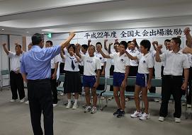 全国大会に出場する学生たちの激励会で、市長と生徒たちが拳を挙げている写真