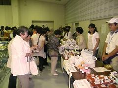 ブースで様々な加工品を販売し、買い物客でにぎわっている摂津東播生活研究グループ実績交換大会の写真