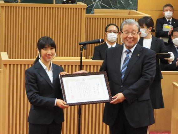 田中選手へ「スポーツ特別栄誉賞」が手渡され、賞を正面に向けている表彰の様子の写真