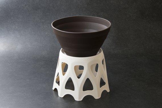 白色で周りを三角形のような形でくり抜かれた円形の台座の上に、焦げ茶色の鉢が置かれている様子の受皿付きスタンド21型MIDの写真