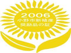 2006小野市新殖産奨励品の証と書かれた黄色いひまわりのロゴ
