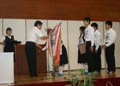 団体総合優勝のトロフィーを受け取る県立浜松商業高等学校生徒の写真