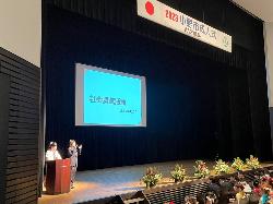 実行委員長が社会貢献活動について発表している様子