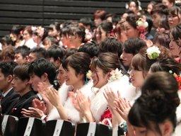 笑顔で観覧する新成人の写真