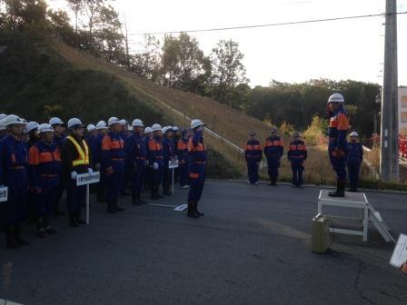 白いヘルメットを被った消防団員たちが訓練開始の号令を受けている写真