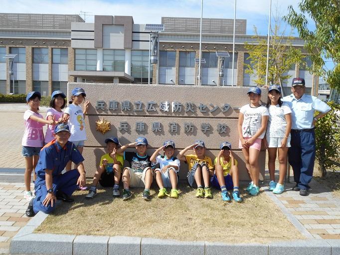 兵庫県消防学校の門の前で10人の参加生徒と2人職員の記念写真