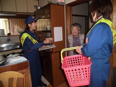 一人暮らし高齢者宅に訪問している消防団女性分団の2人と高齢の女性の写真