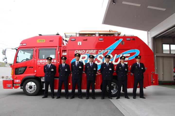 消防車の前で制服姿で整列する水難救助隊員たちの写真 羽原靖幸