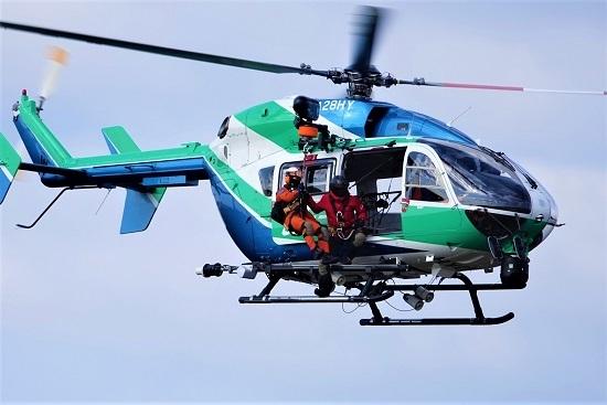 ヘリコプターからオレンジ色の男性が横へ出ている写真