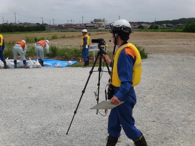 黄色いベストを着た作業員の男性が画像撮影システムを使っている写真