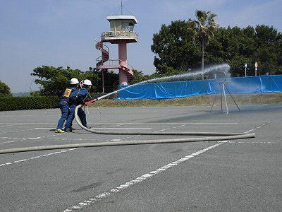 消防隊員が二人がかりで放水作業をしている写真