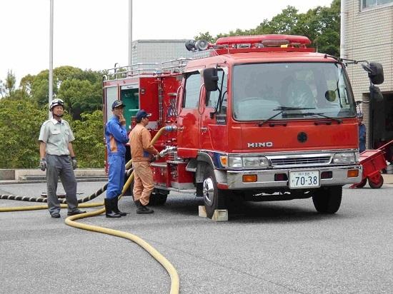 消防署の駐車場で旧化学車の取扱い訓練を受けている職員たちの写真