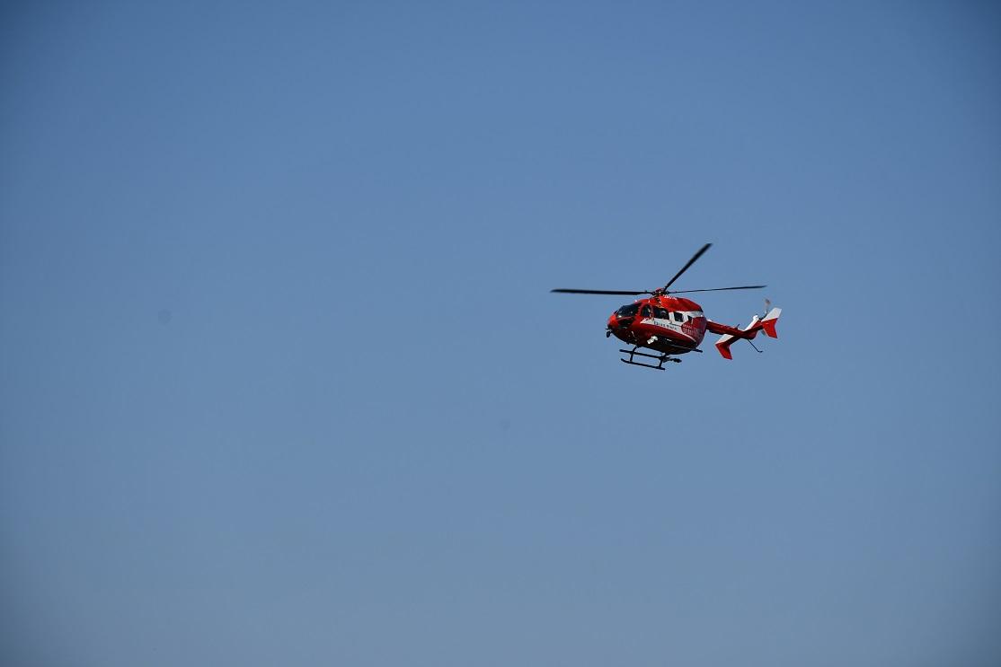 青い空に赤い救助用ヘリが飛んでいる写真