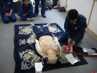 実際に人形でAEDの使用方法を実践している消防団員の写真