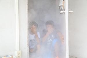 二人の男の子が煙体験をしてドアから出てくるところの写真