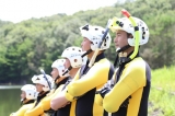 ヘルメットを被っている水難救助隊の隊員が水辺に6人並んでいる写真