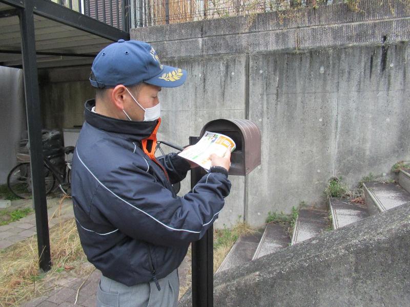 住宅用火災警報器の調査用紙を投函する様子