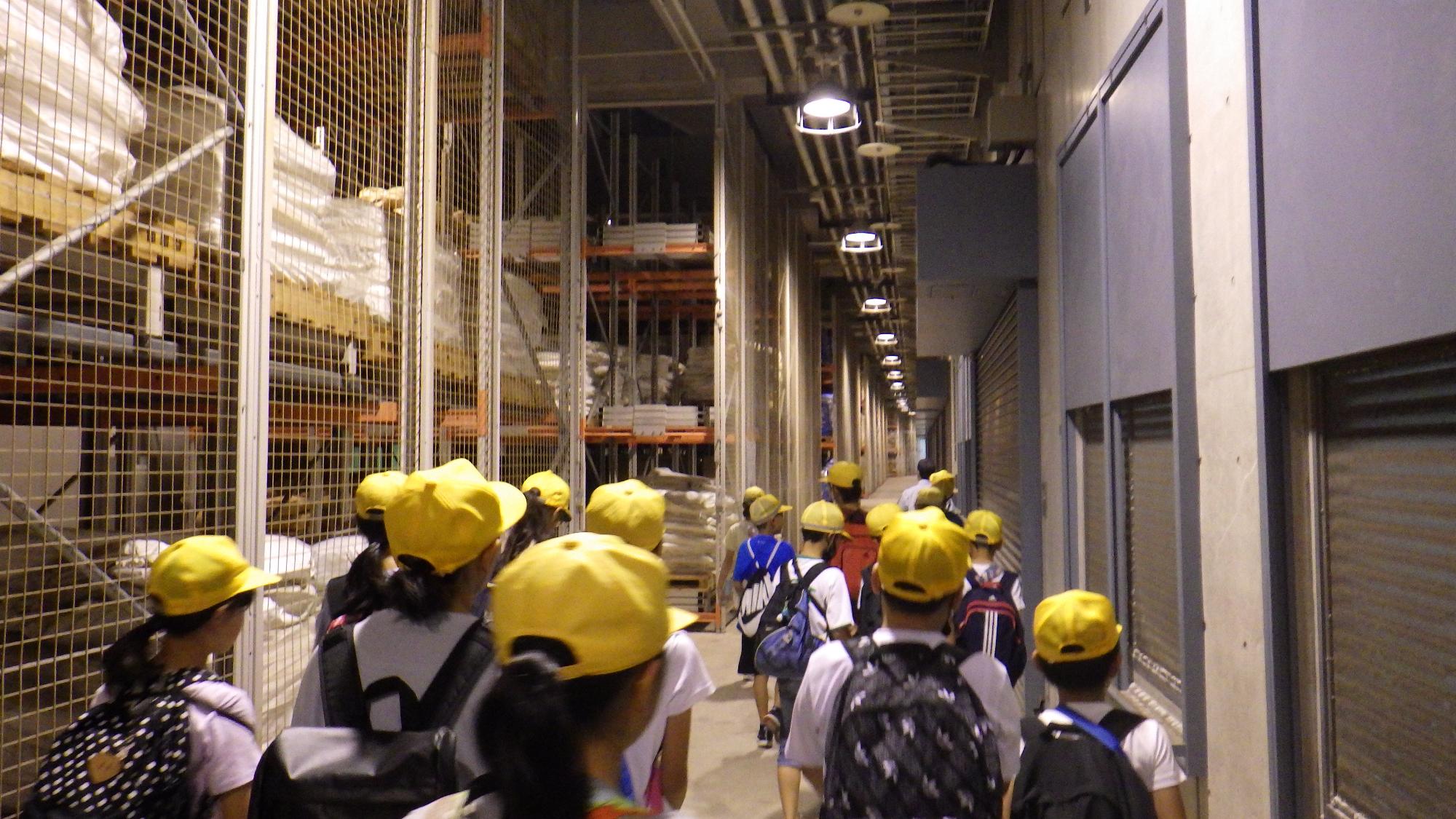 大きな防災備蓄倉庫の中を見学している生徒たちの写真