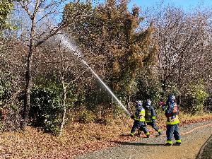 小野市浄谷町小野希望の丘陸上競技場アレオの林野火災訓練現場にて現場に向けて放水する消防隊員