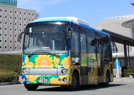 ヒマワリのイラストがラッピングされたらんらんバスの車両外観の写真