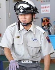 黒いゴーグルのついた白いヘルメットをかぶり、灰色の半そでの消防士の制服を着て写真に写る藤原 悠暉さんの写真